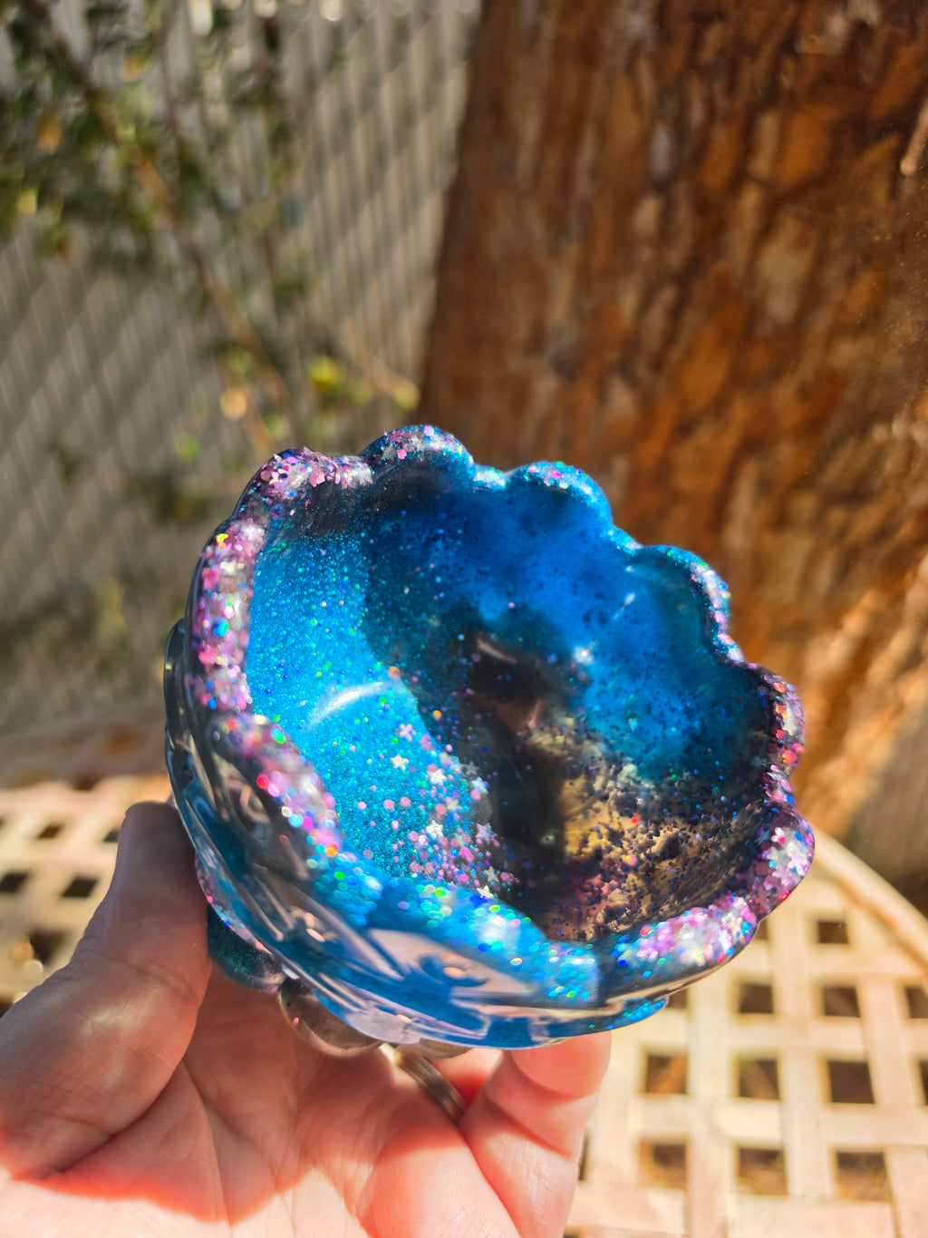 Interior view of galaxy resin bowl showing blue teal and iridescent star glitter lining