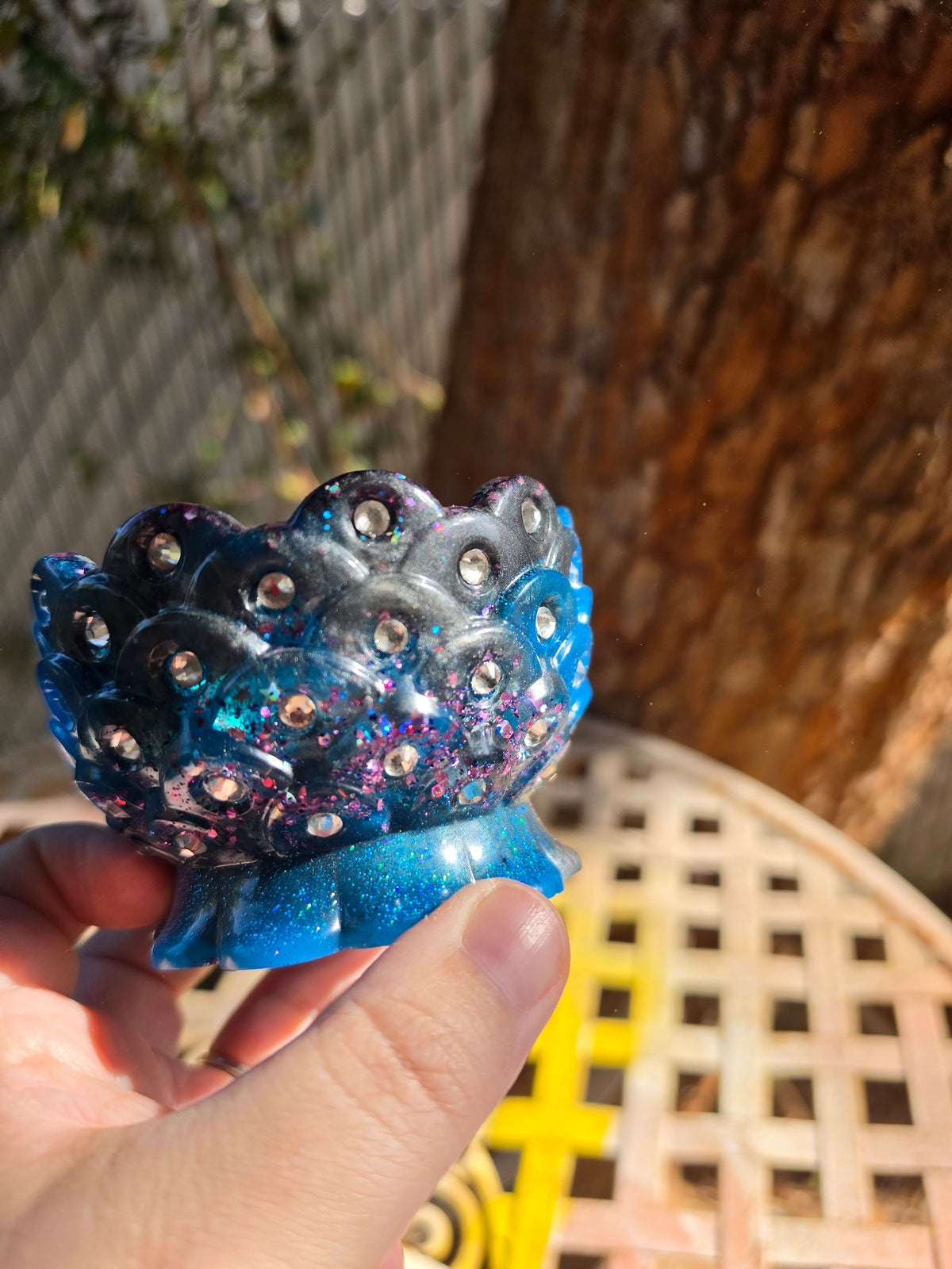 Bottom view of rhinestone resin bowl showing cobalt blue and grey swirl with holographic glitter