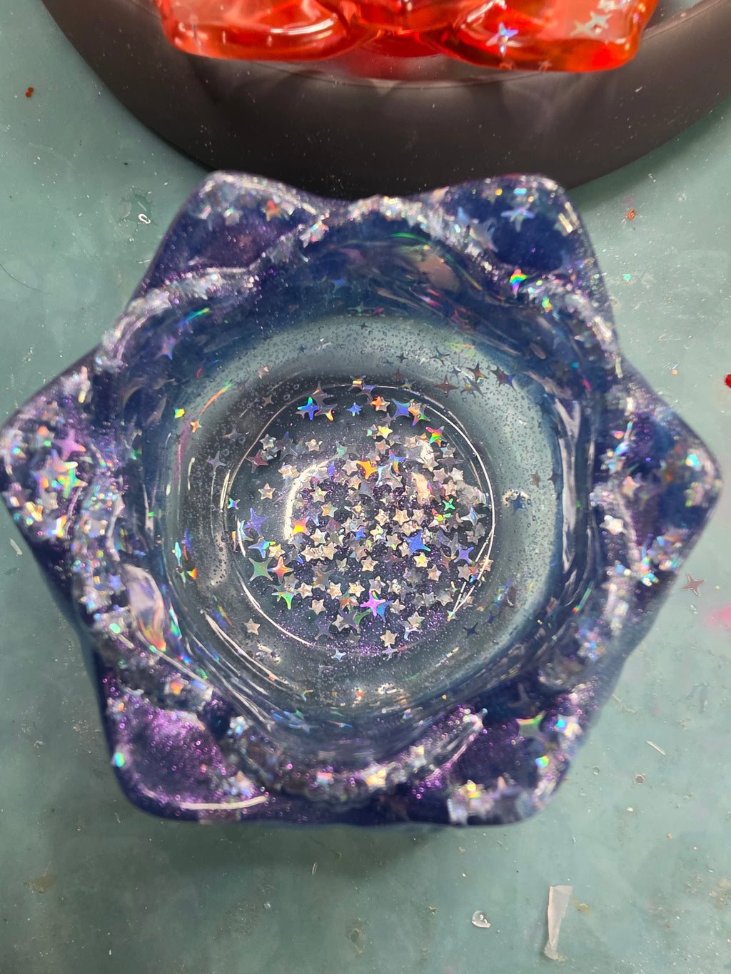 Overhead view of deep violet galaxy lotus dice throne showing full bowl of iridescent star glitter