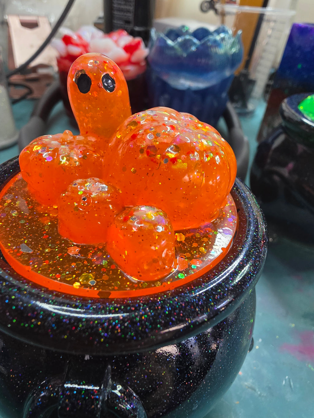 Detailed close-up of ghost and pumpkin bubble resin lid showing chunky holographic glitter detail