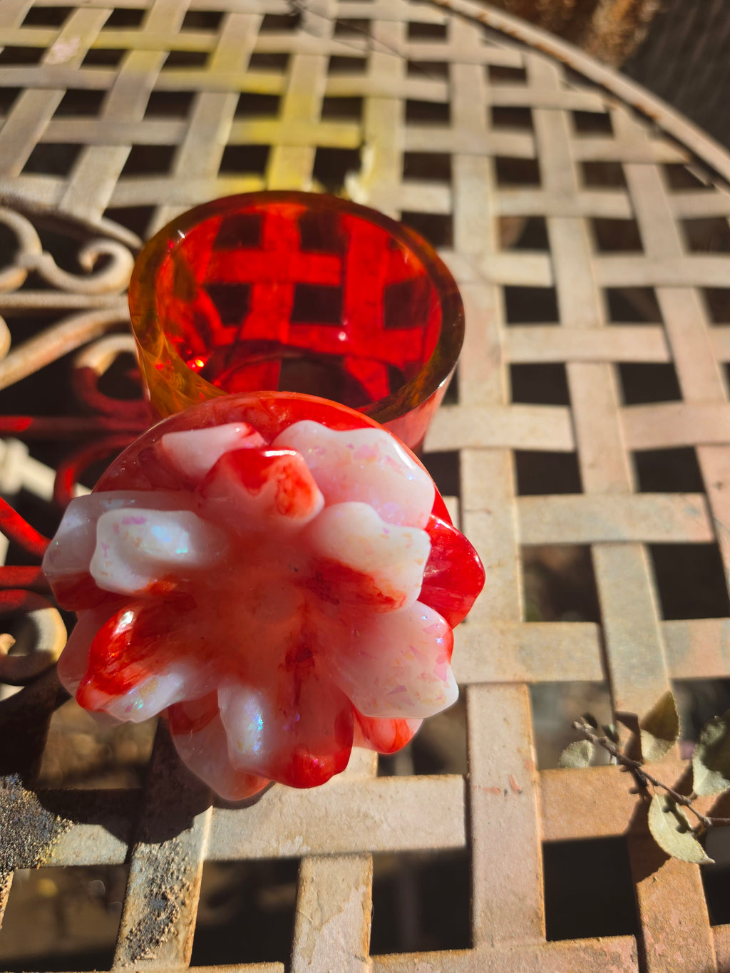 Close-up of sculpted white and red resin flower lid