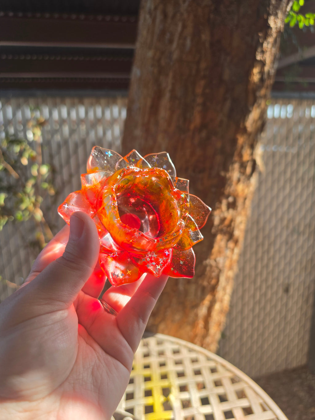 Top-down view of red resin lotus throne showing deep center bowl with iridescent star glitter