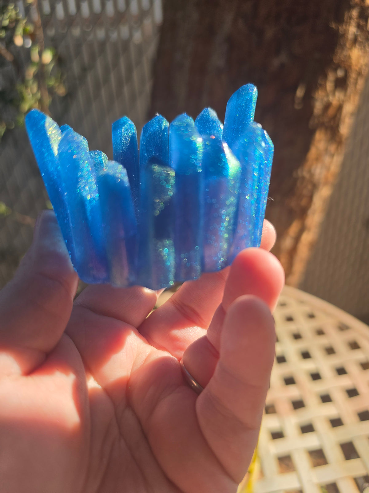 Side view of sapphire blue crystal cluster resin dice throne showing pointed spires and teal shimmer