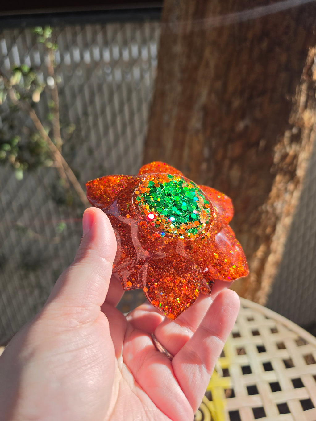 Held in hand showing the size and depth of the lotus resin tealight and dice holder