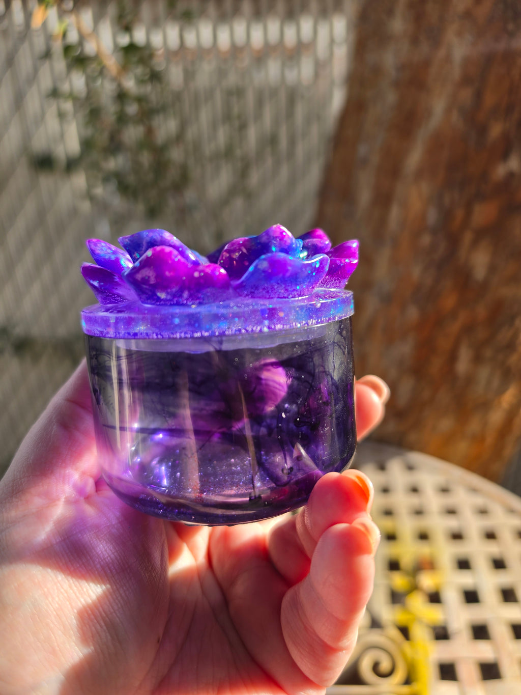 Close-up of galaxy-inspired floral resin lid with shimmering flecks