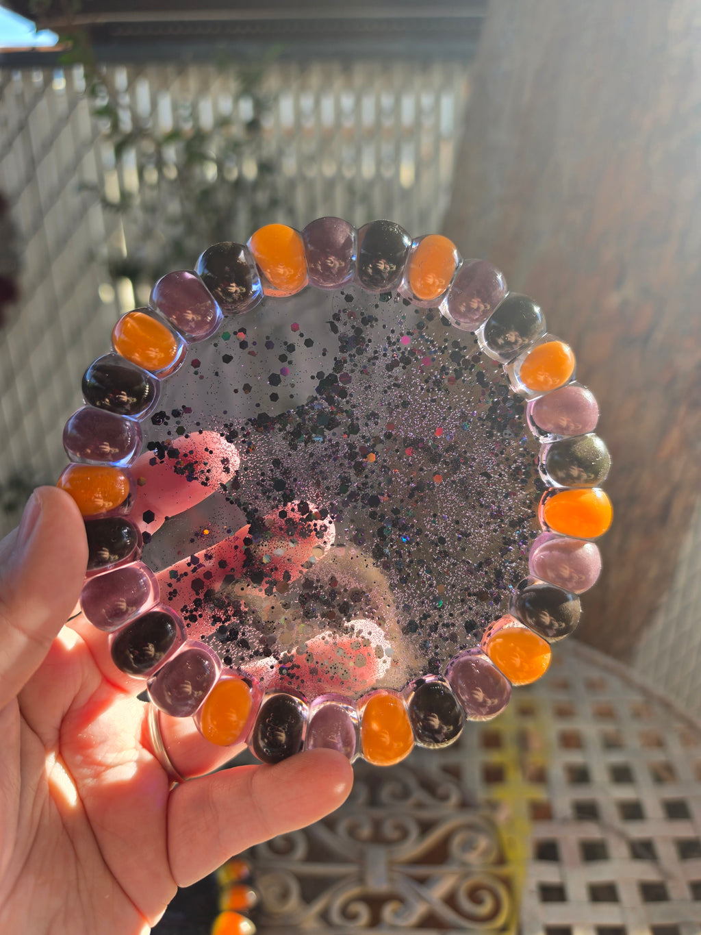 Halloween resin trinket tray with orange, purple, and black jelly beans around the rim