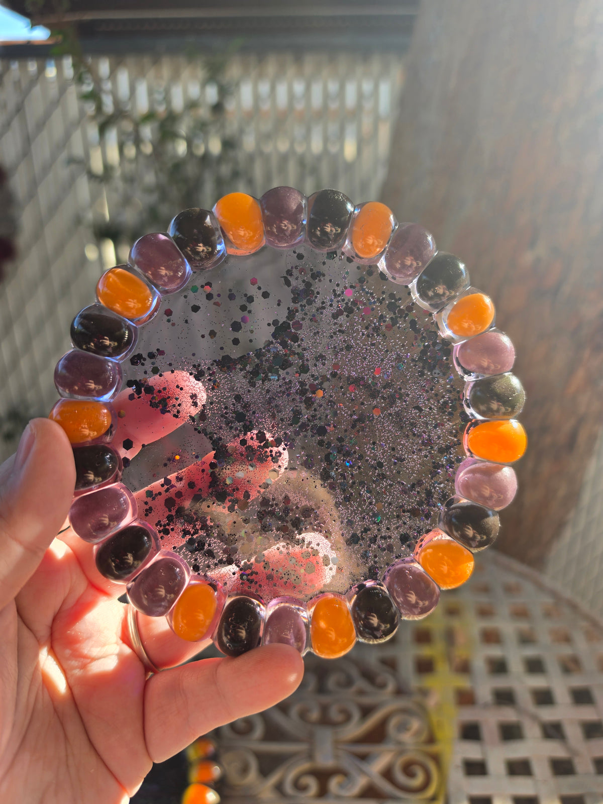 Halloween resin trinket tray with orange, purple, and black jelly beans around the rim